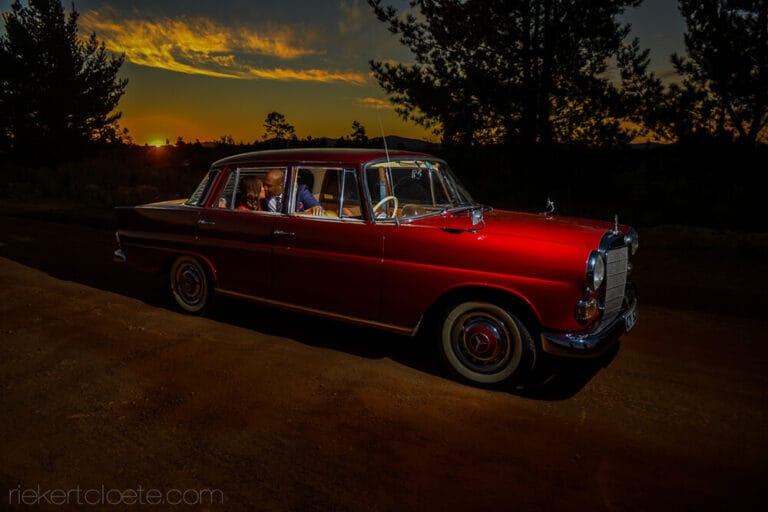 Couple with old wedding car