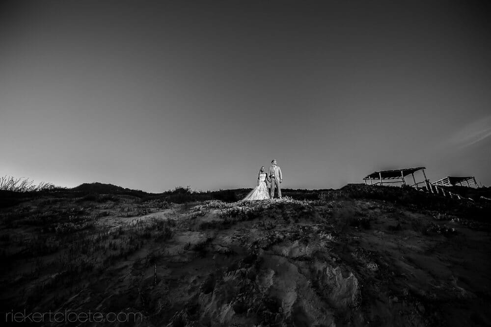 wedding couple in grassy sand hill