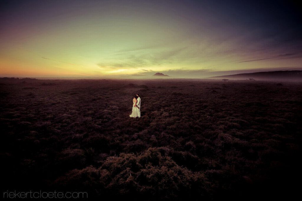 Bride and gropm in a field at sunset