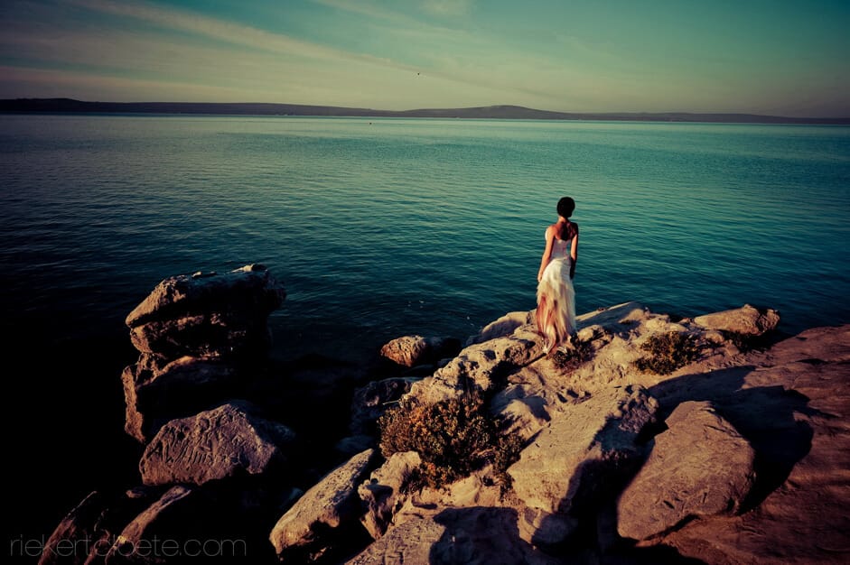 Bride on rocks overlooking the sea