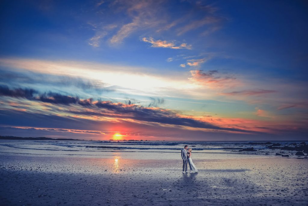 Bride and groom on the beach at sunset