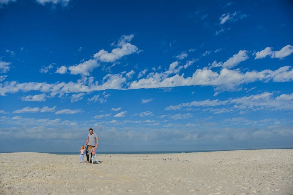 Dad and daughters walking on the beach
