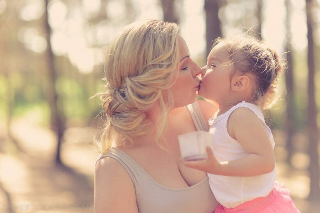 Mom kissing daughter