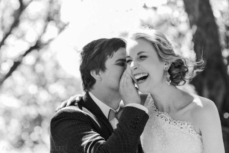 Groom wispering in bride ear