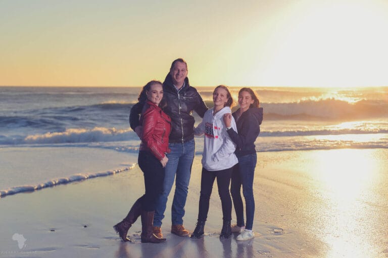 Family of four standing on the sand during a family shoot in Cape Town