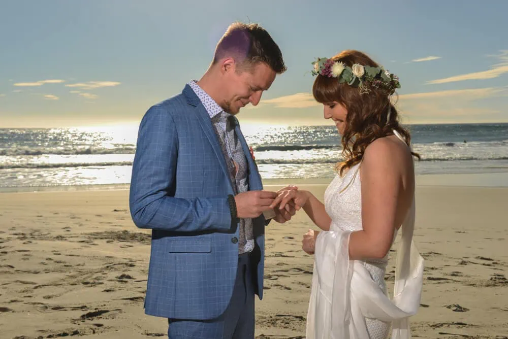 beach wedding ring exchange sunset flower crown