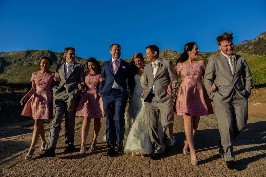 bridal party laughing walking cape mountain backdrop