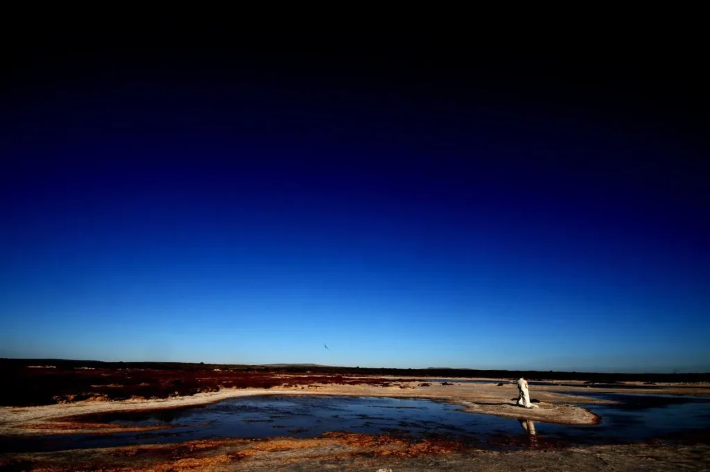 bride alone salt pan vast dramatic sky
