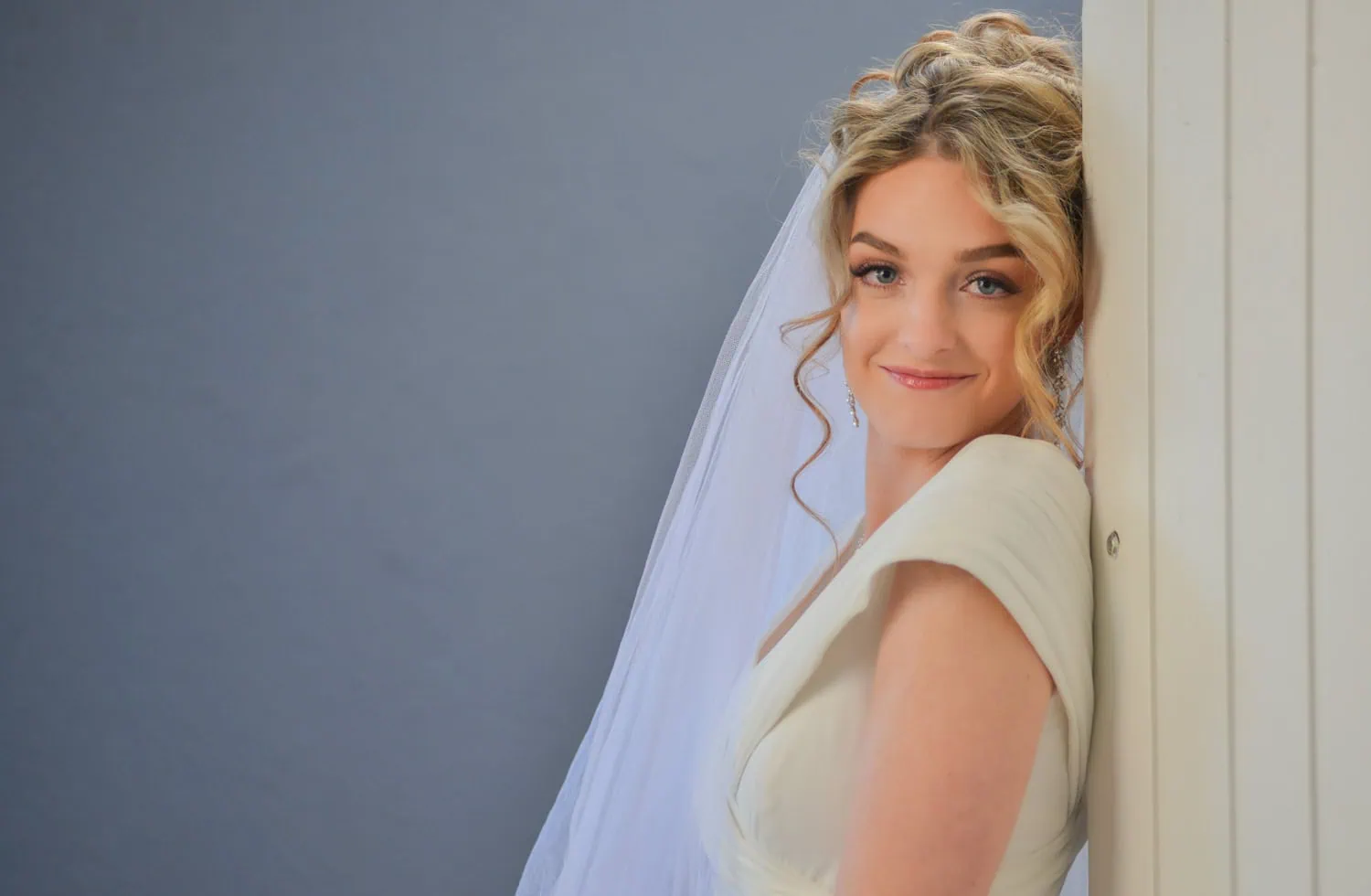 bride curly updo veil satin gown leaning column