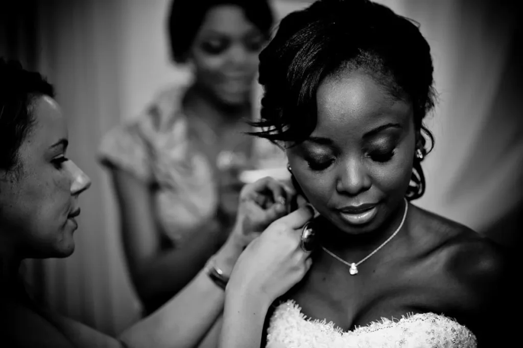 bride earring fitted by makeup artist getting ready