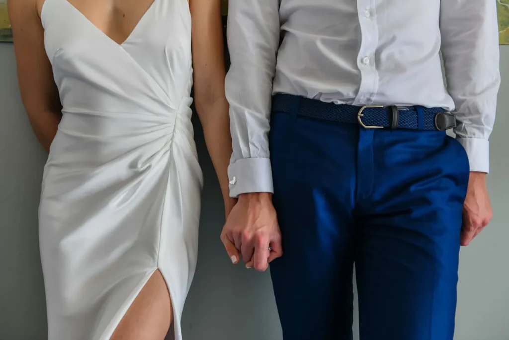 bride groom clasping hands white dress blue trousers