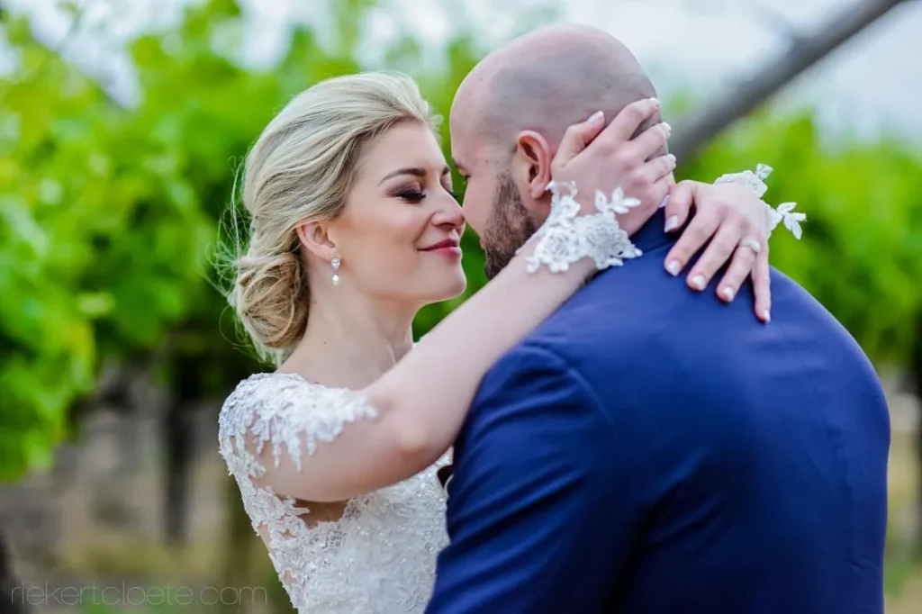 bride groom embrace vineyard lace wedding gown