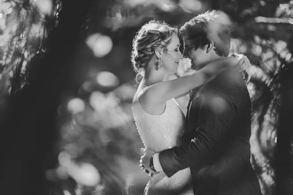 bride groom embracing trees dappled light