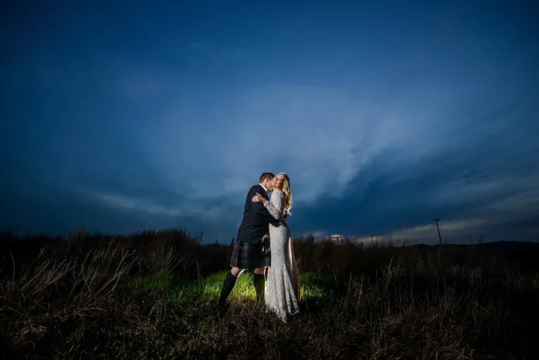 bride groom kilt dusk field moody blue sky