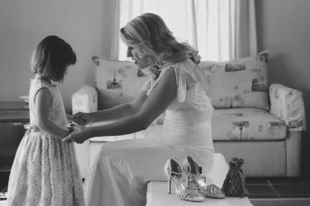 bride holds hands with flower girl getting ready
