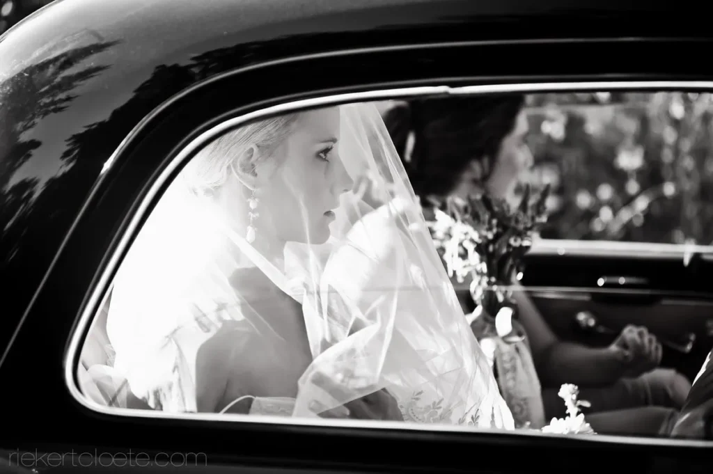 bride in veil vintage car window before ceremony