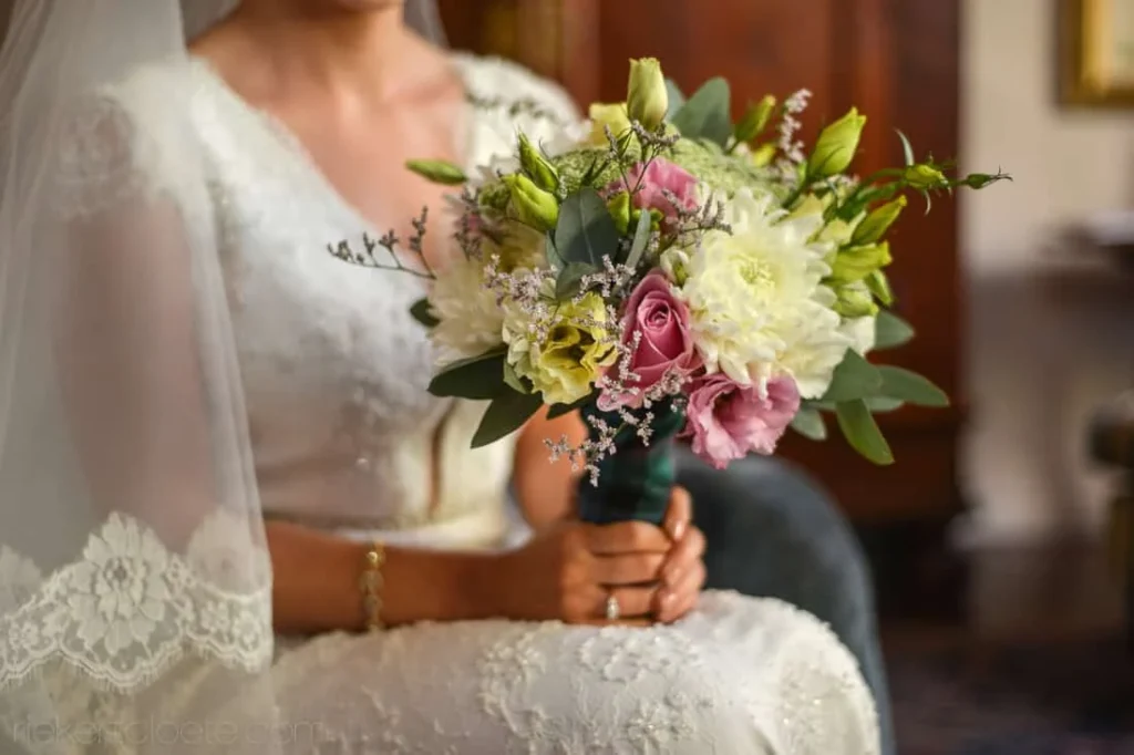 bride lace gown mixed flower bouquet seated