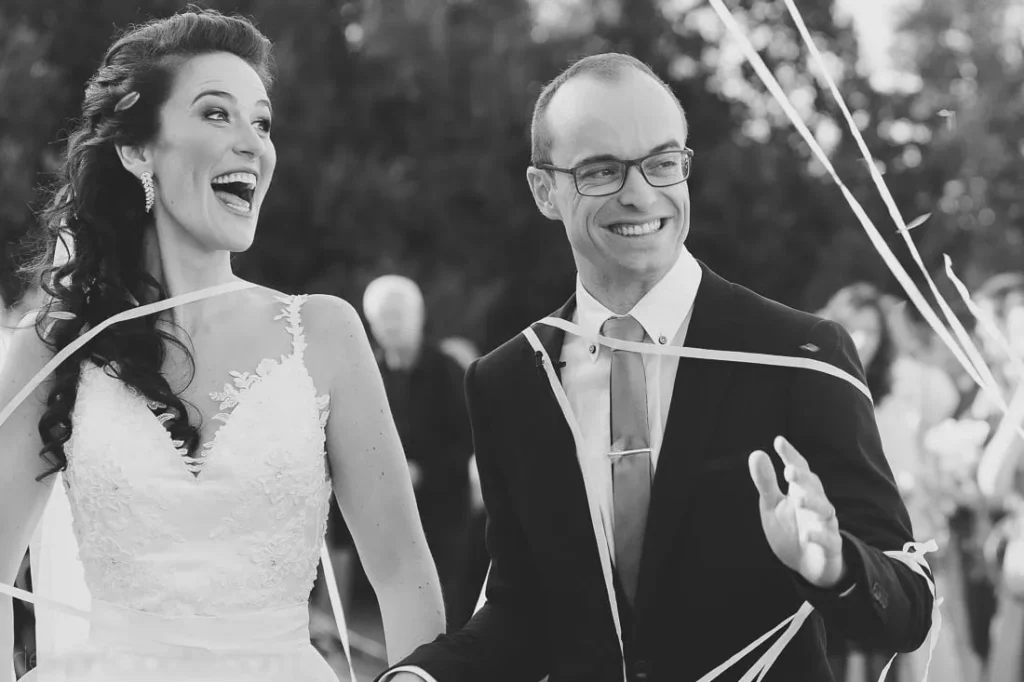 bride laughing groom smiling ribbon confetti exit