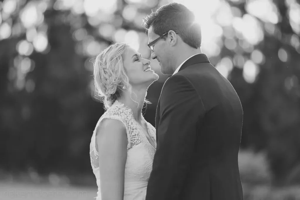 bride laughing nose to nose groom outdoor bw
