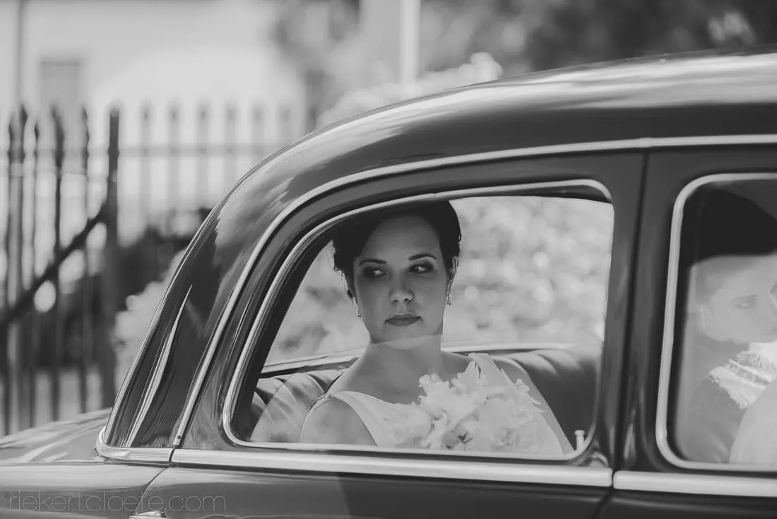 bride looking out vintage wedding car window