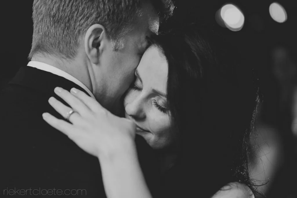 bride pressed grooms chest wedding ring visible