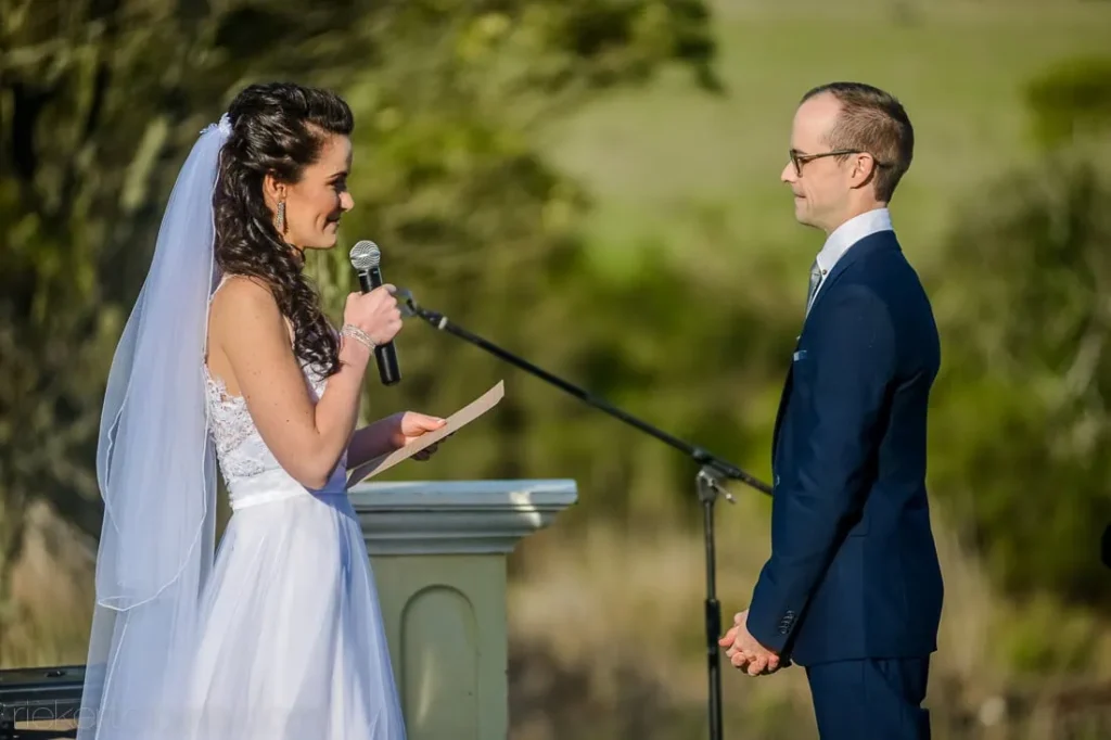 bride reading vows microphone outdoor ceremony