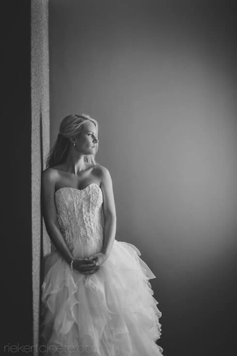 bride ruffled ballgown leaning wall portrait