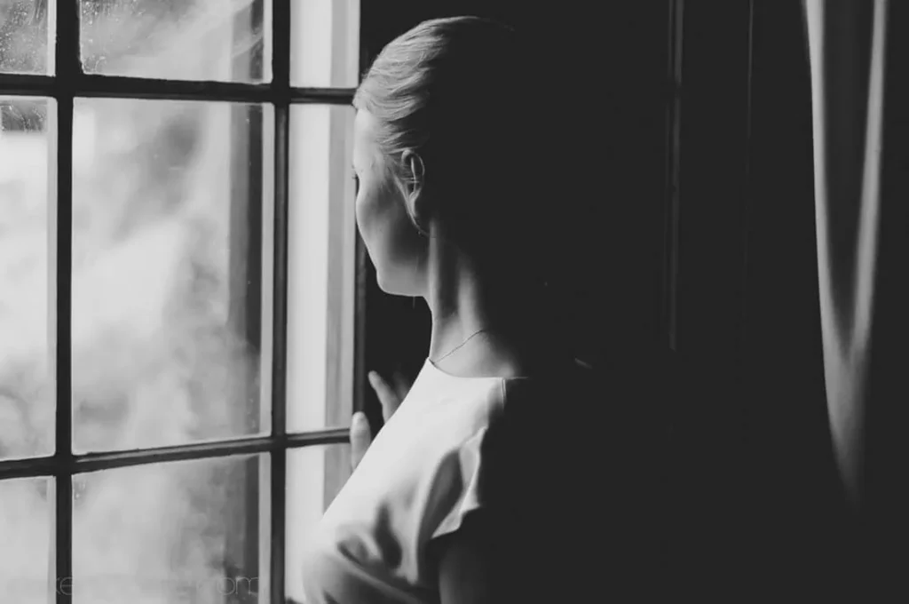 bride seated bed veil window light contemplative