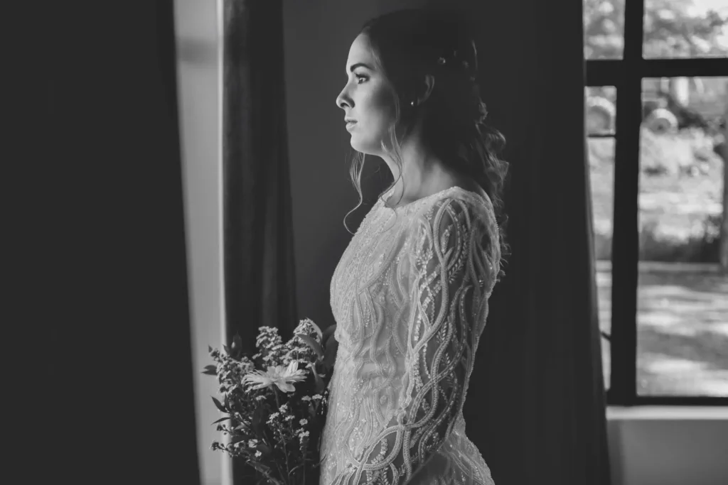 bride textured lace gown wildflower bouquet window
