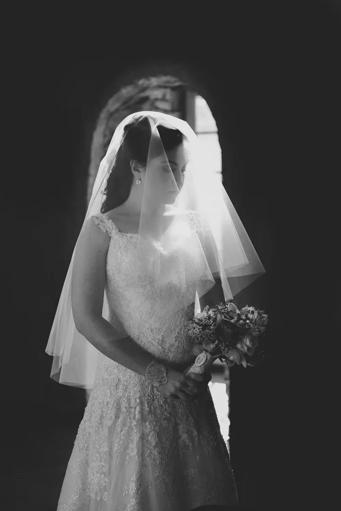 bride veil face archway bouquet dramatic portrait