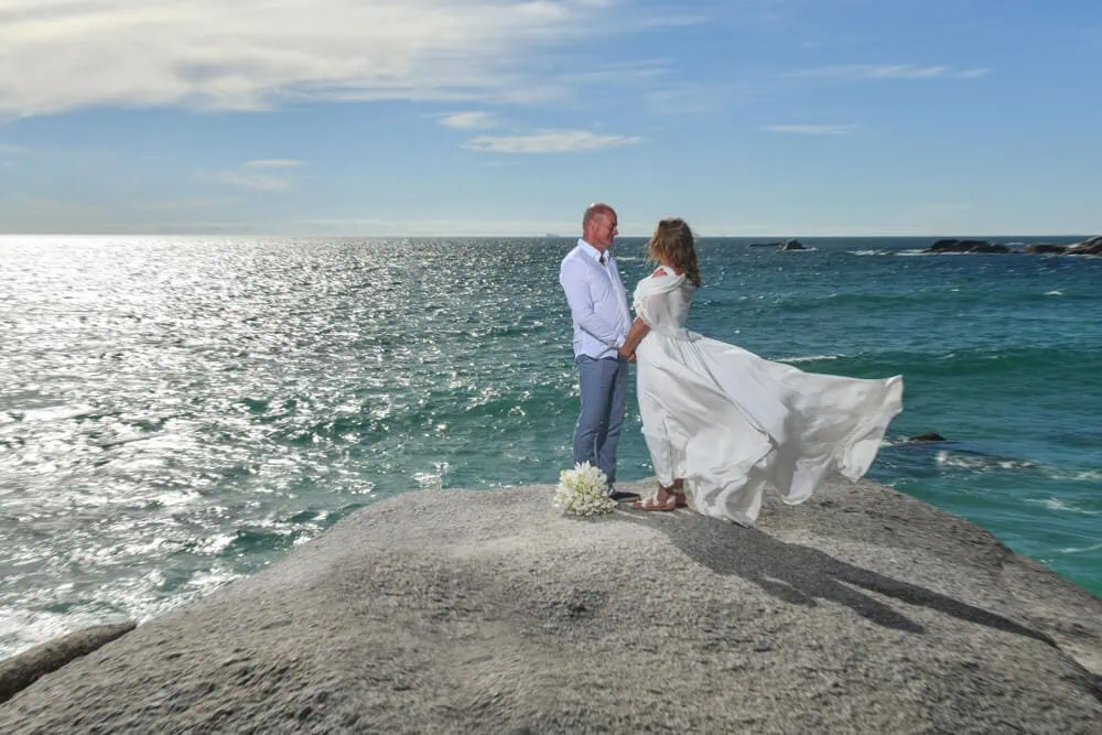 camps bay couple on rock overlooking atlantic ocean
