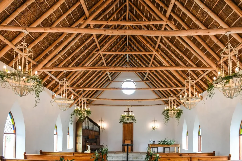 chapel thatched roof wooden rafters hanging chandeliers