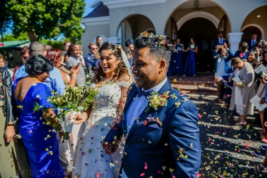 couple confetti arched church blue bridesmaids celebration