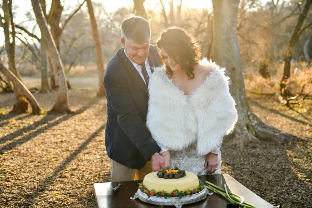 couple cutting cake golden hour outdoor winter