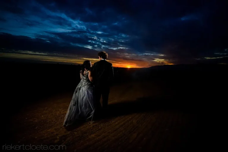 couple dark gown sunset dramatic clouds landscape