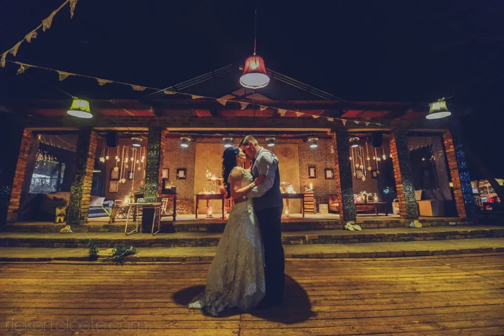 couple embrace rustic lit barn venue night