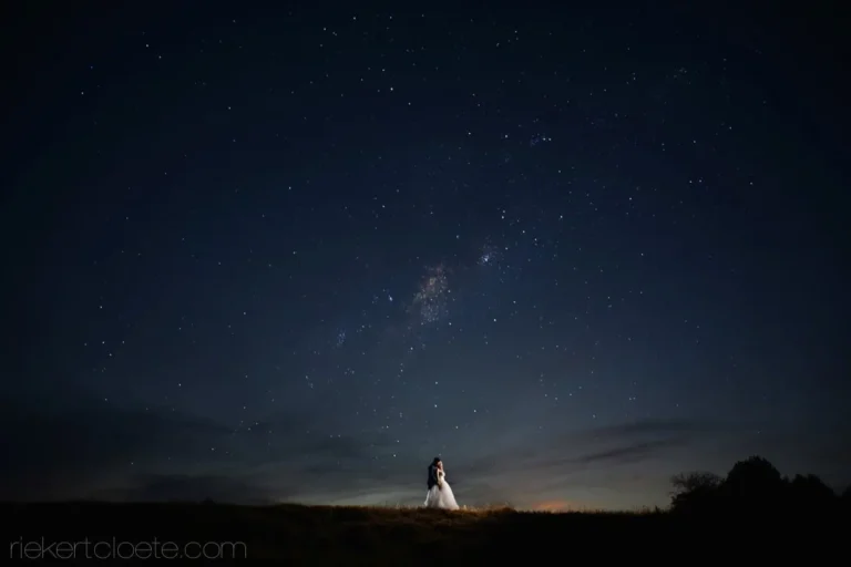 couple embracing milky way starfield hilltop night