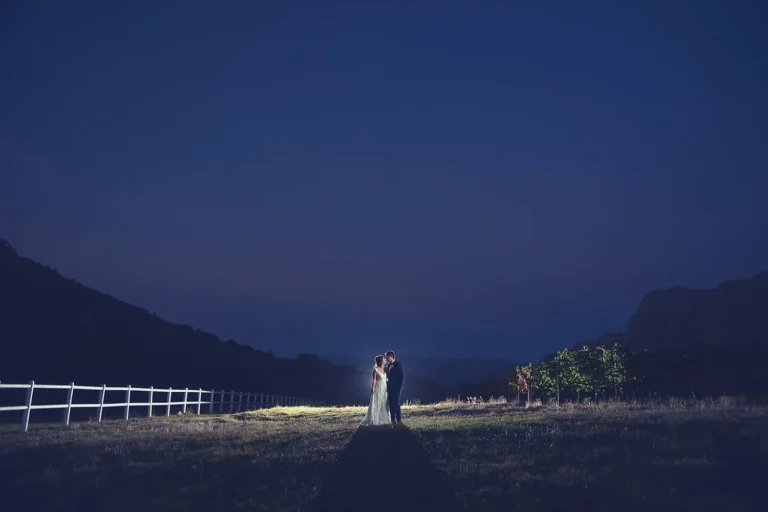 couple embracing night farm field mountain backdrop