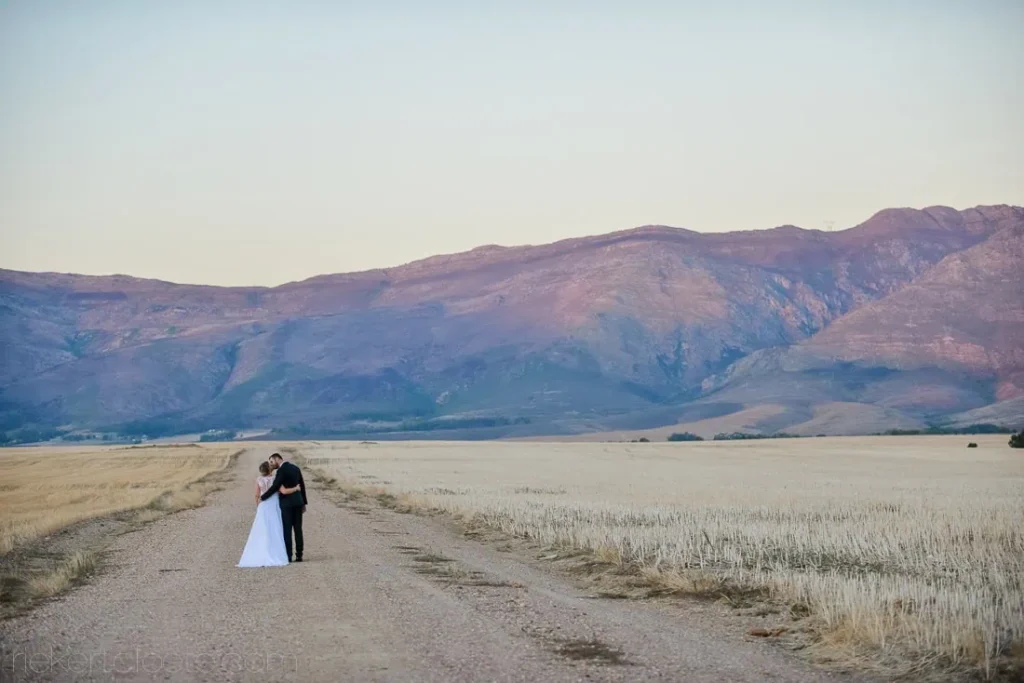 couple embracing open wheat fields purple mountains