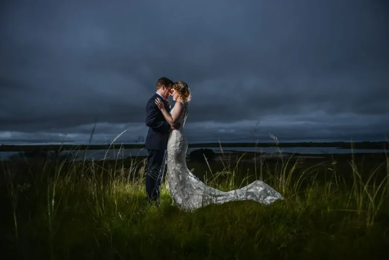 couple embracing tall grass lake stormy night