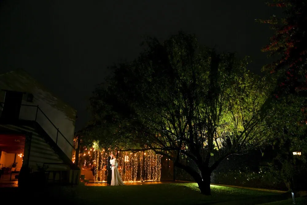 couple fairy light curtain lit tree winelands venue