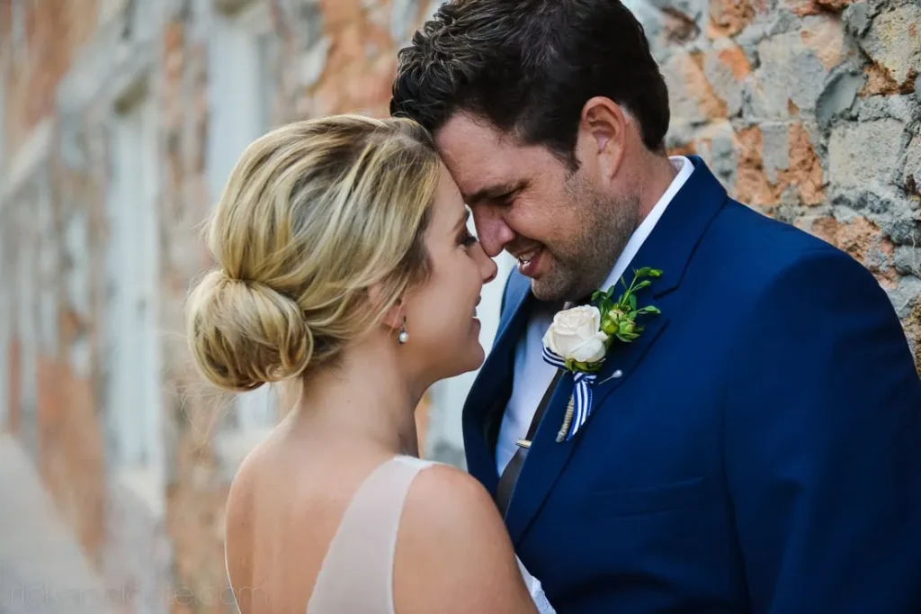 couple forehead touch rustic stone wall portrait