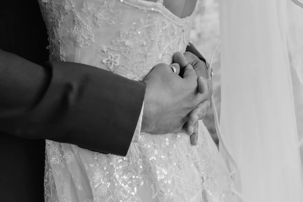 couple holding hands wedding rings close up ceremony