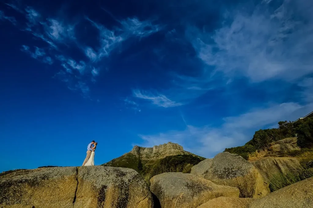 couple kissing coastal boulders table mountain