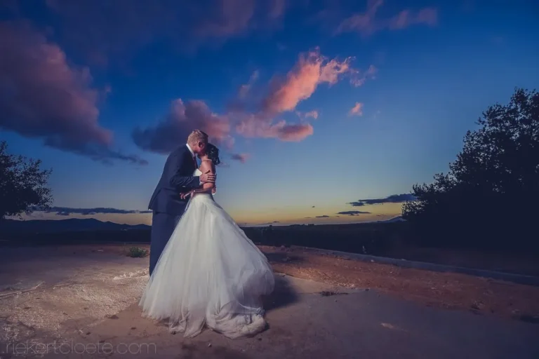 couple kissing dusk dramatic pink blue cloudy sky