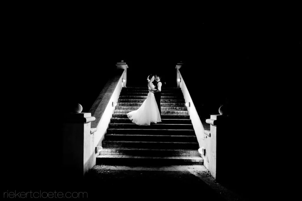 couple kissing grand staircase night black white
