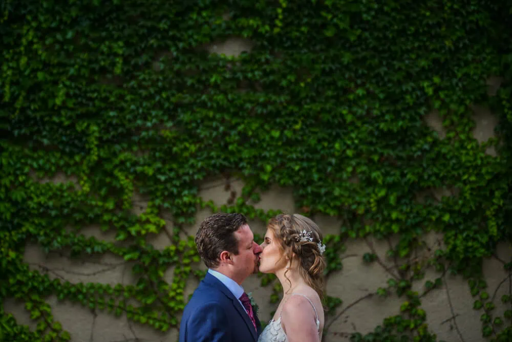couple kissing lush ivy covered wall cape town