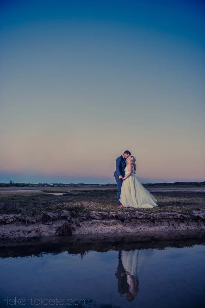 couple kissing twilight salt pan pink sky reflection