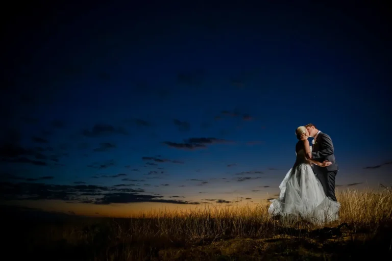 couple kissing wheat field deep blue dusk sky