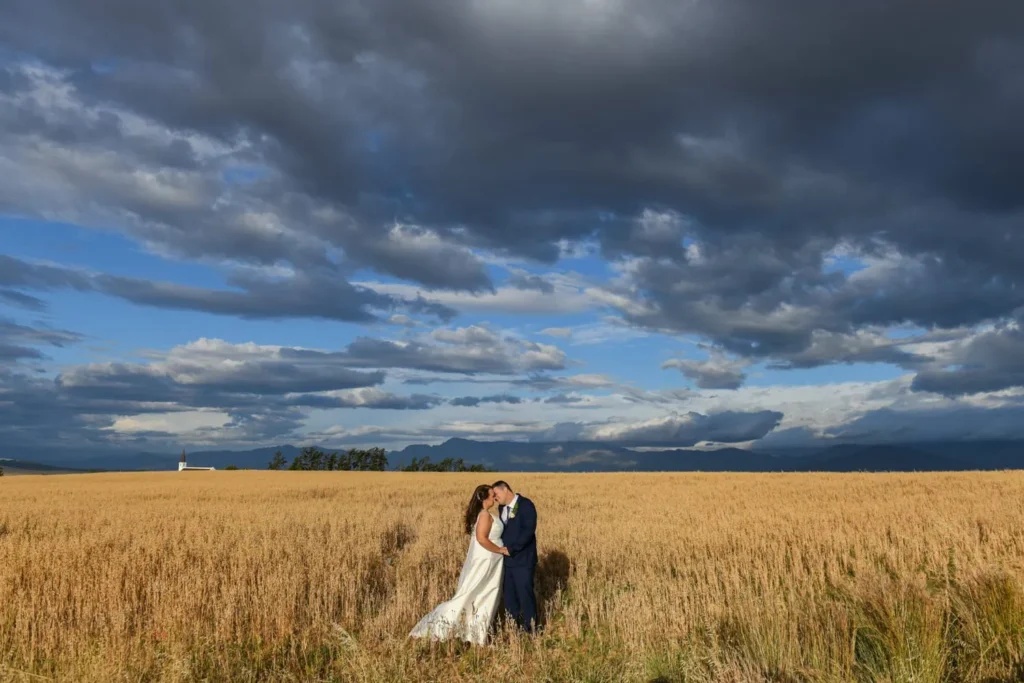 couple kissing wheat field dramatic storm clouds